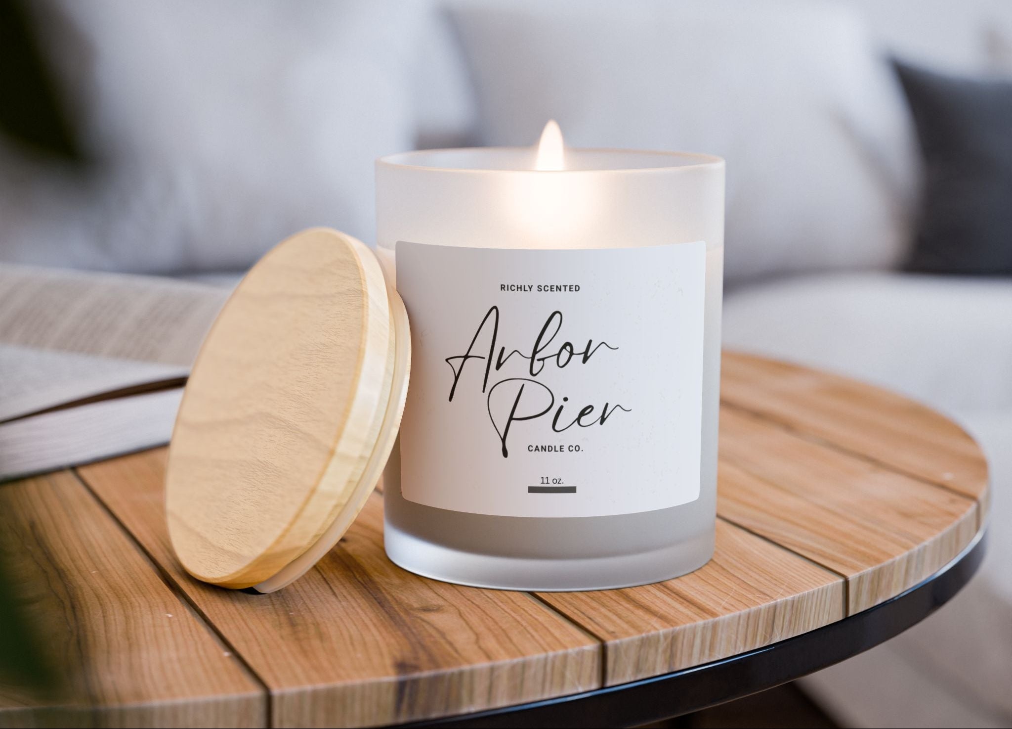 Candle on a wooden table with a blurred indoor background